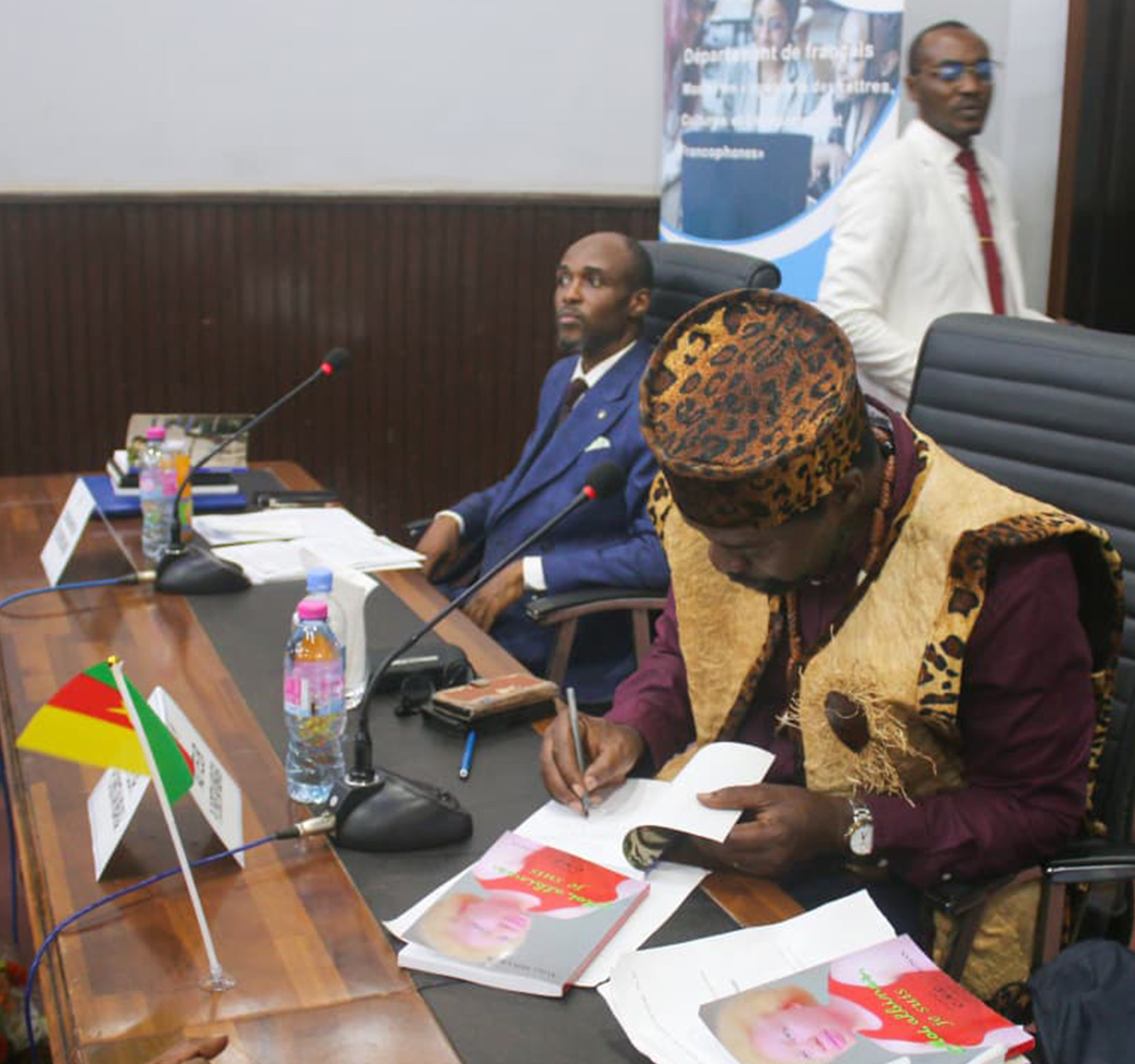 Dr. Christian Mbarga signs a copy of his new book at a launch in Cameroon