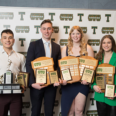 Four student athletes with awards