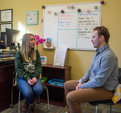 Career Development Advisor Erin Feicht sits in her office with a student