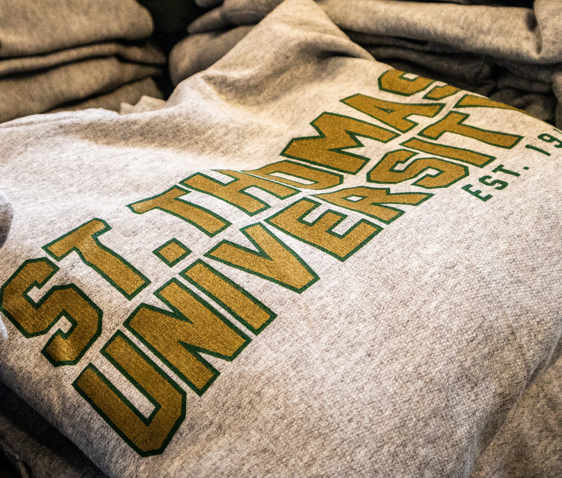 A great St. Thomas University sweatshirt, folded on the table