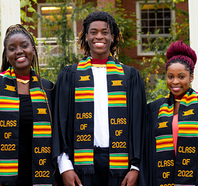 Three Black students proudly showcasing their Kente Stole