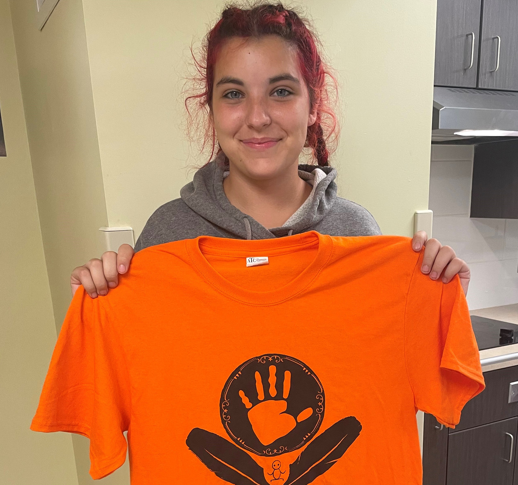 Student holding Orange Shirt