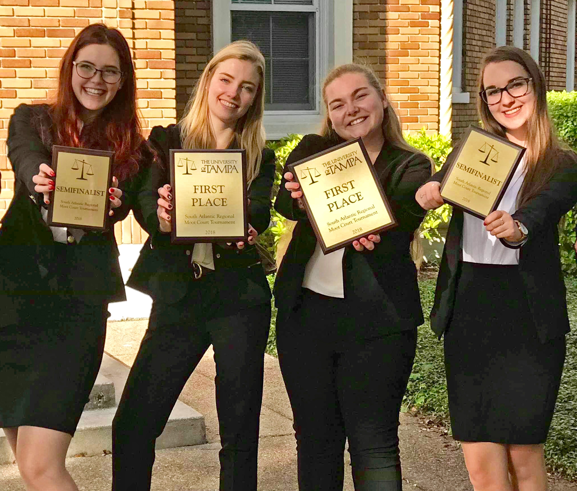 photo of four female students holding out awards.