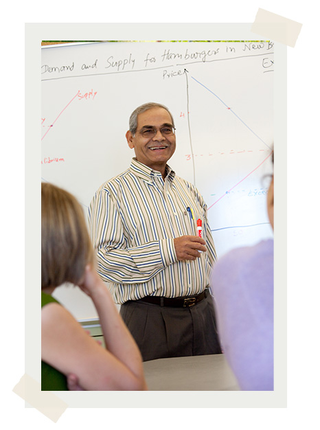 Dr. Dev Gupta standing in front of a whiteboard in a classroom