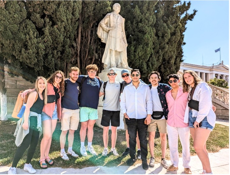Students on experiential learning trip in Greece standing in front of sculpture