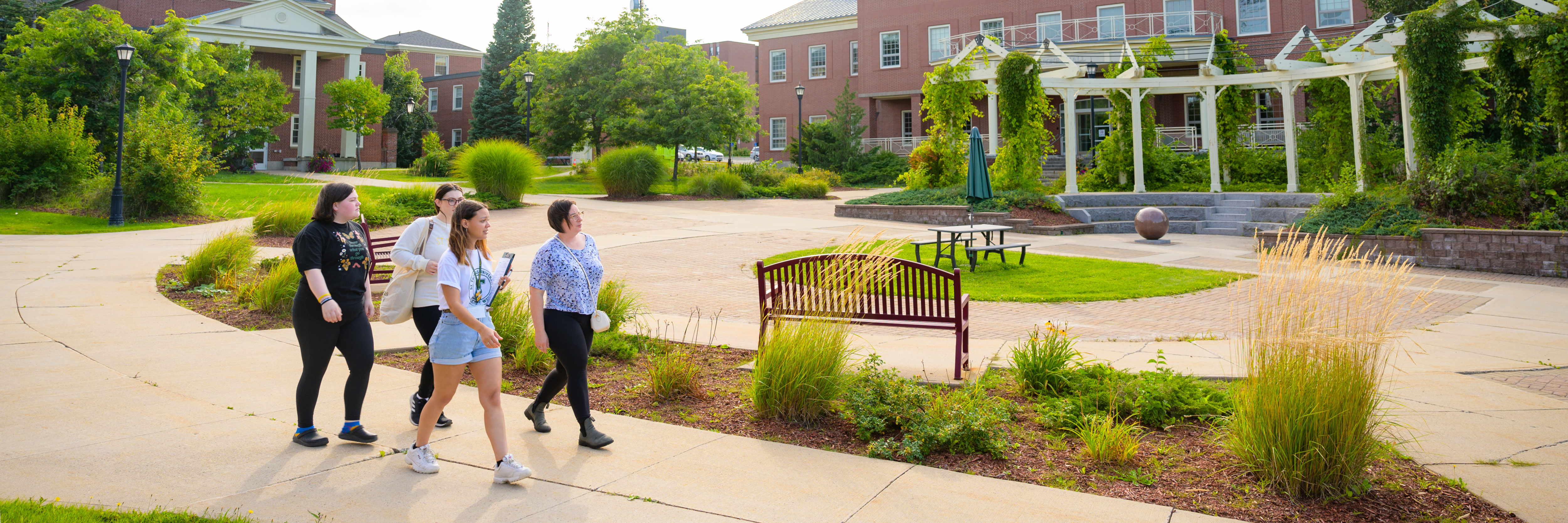 A photo of three students walking down the centre of STU campus