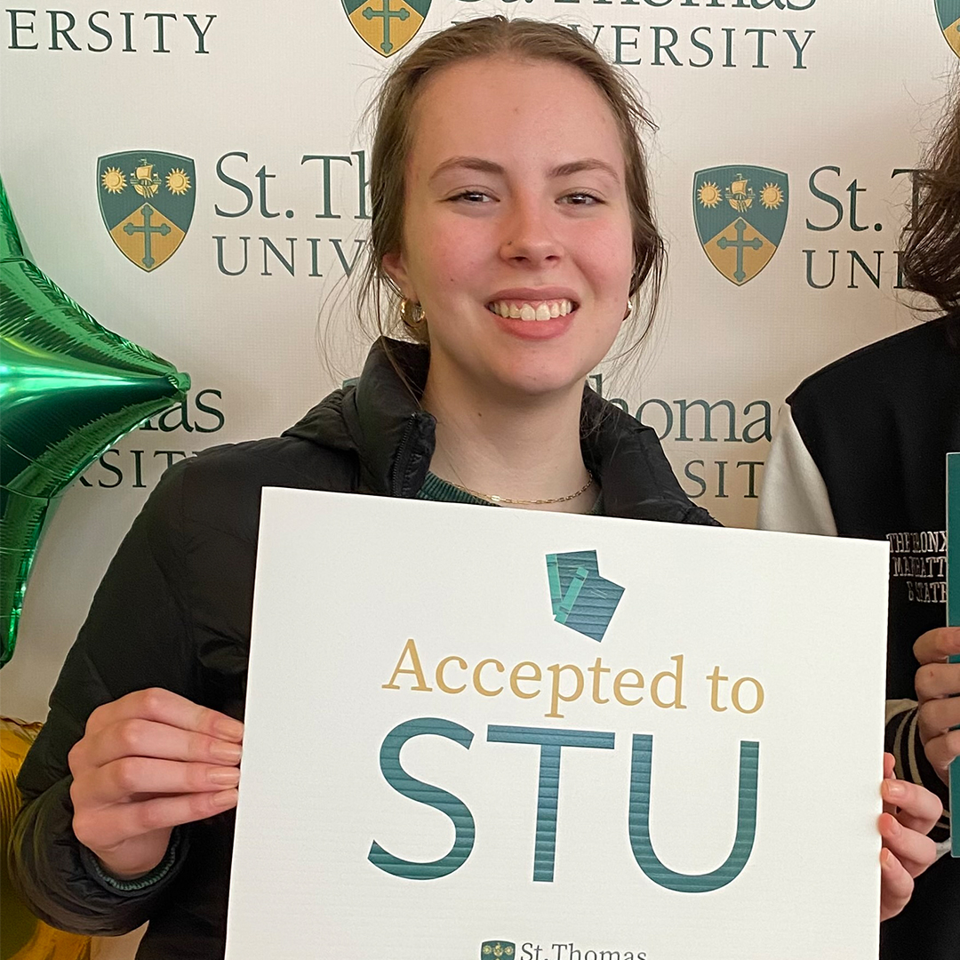 Olivia Jordan holding an Accepted to STU sign